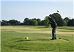 Man Teeing off at a Golf Course